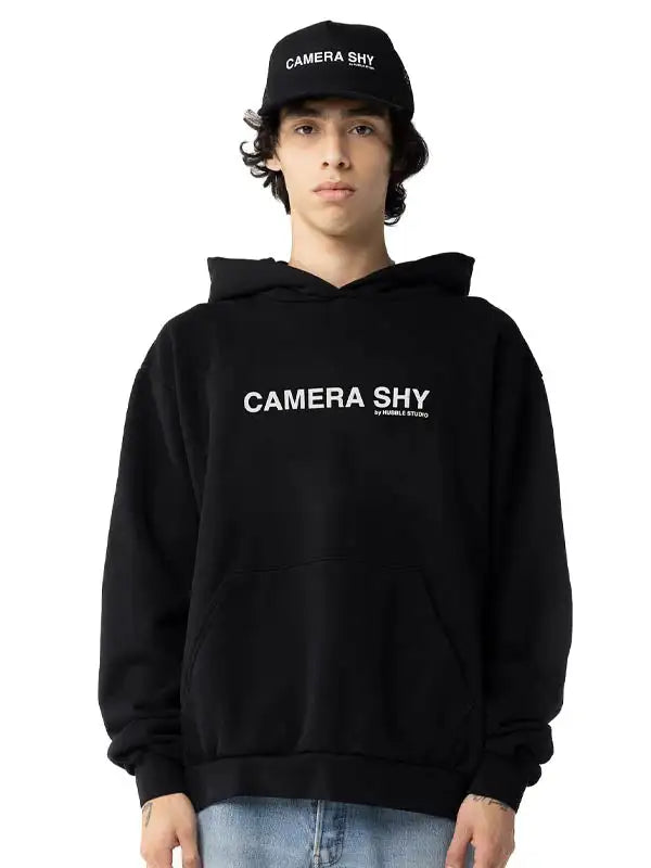 Front view of a man wearing the CAMERA SHY Hoodie in black