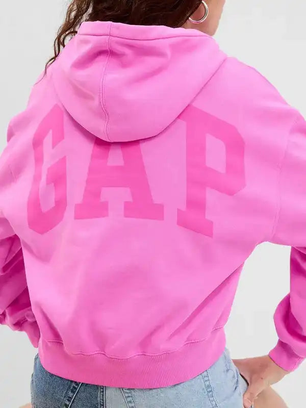 Back view of a woman wearing a bright pink cropped pullover hoodie